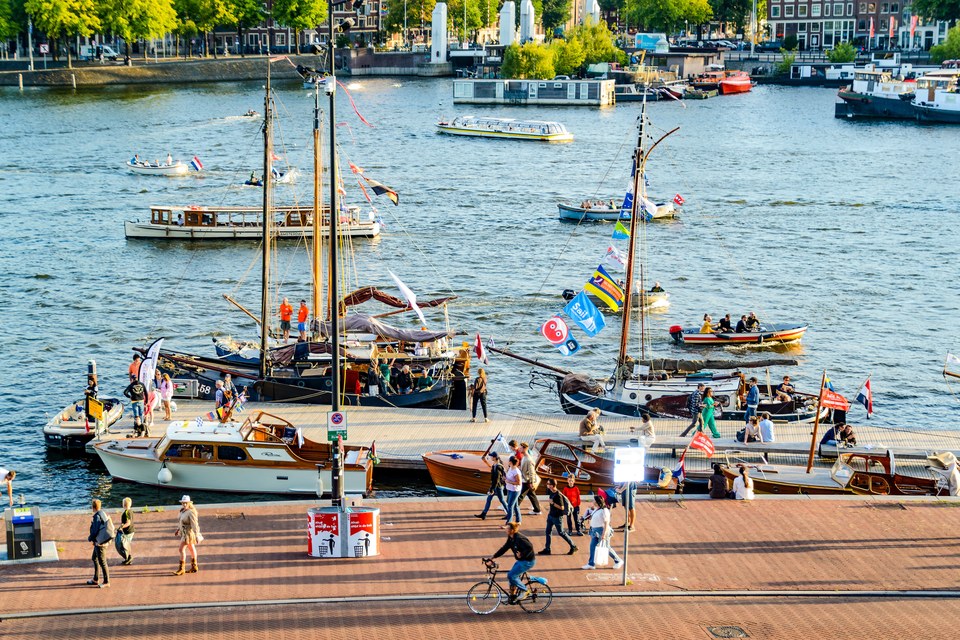 Sailing boats and visitors along the Amsterdam waterfront.