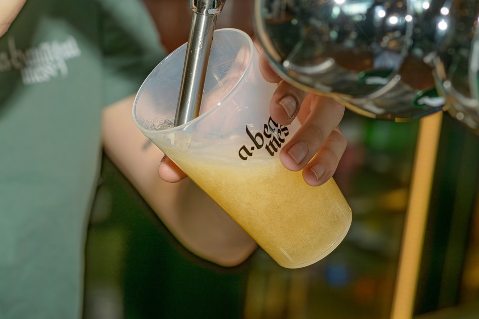 A drink is poured into an A Beautiful Mess cup.
