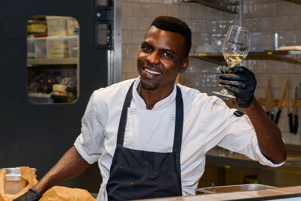A smiling chef raises a wine glass at the end of the evening.