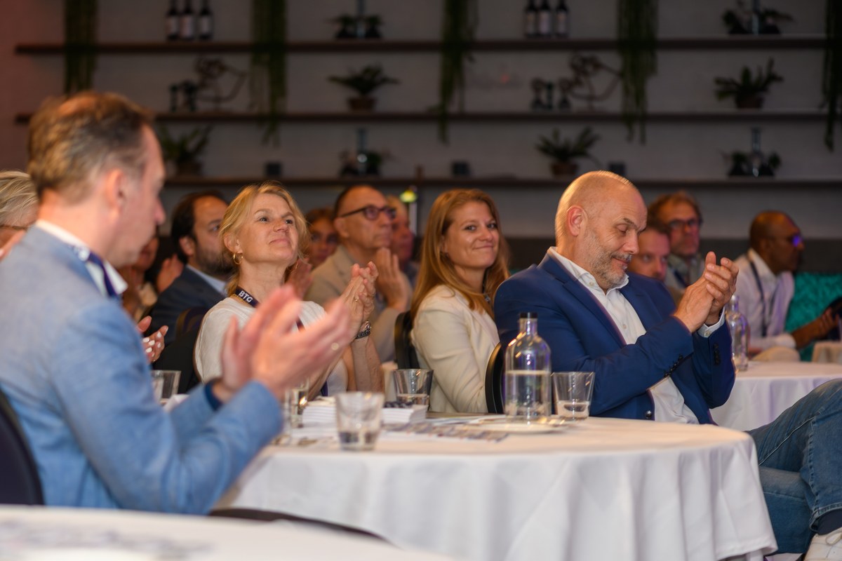 Audience members applaud at their tables.