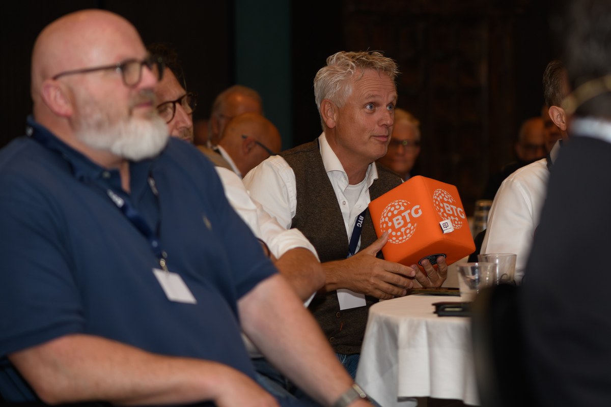 Guests at a table listen during the programme.