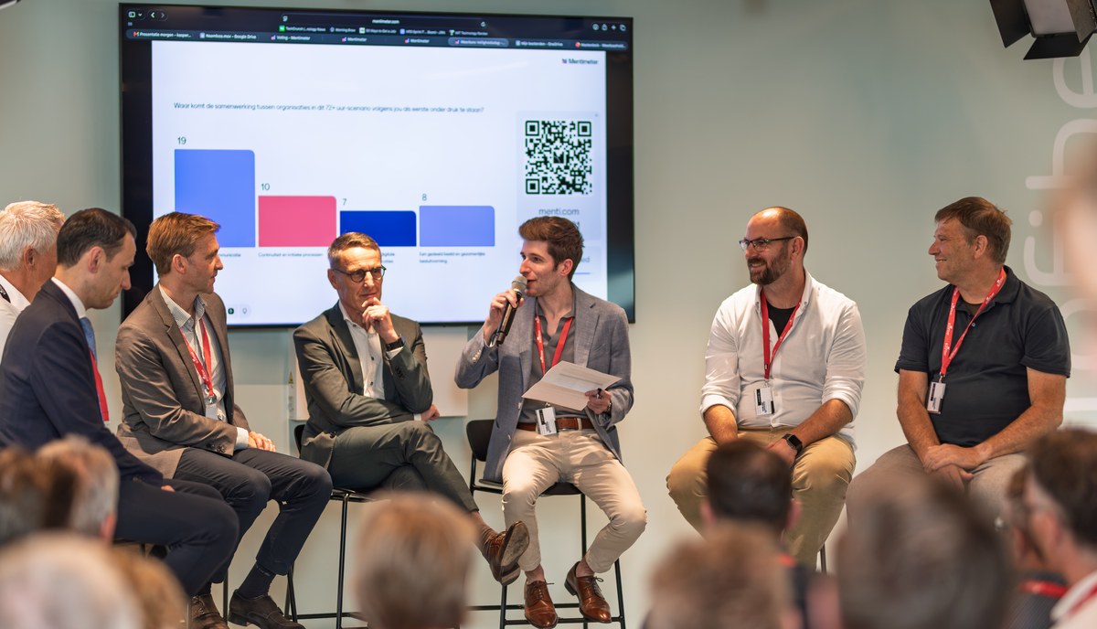 Five panellists exchange views in front of a presentation screen.