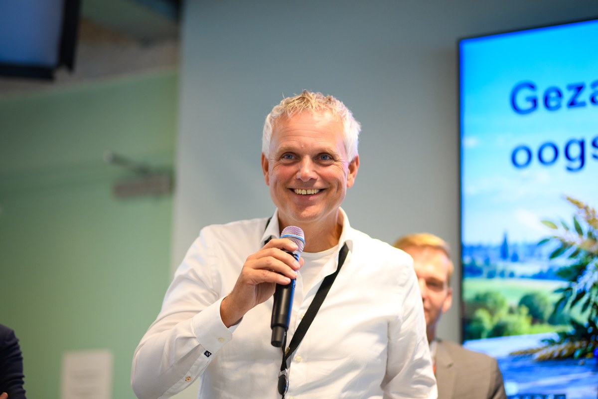 A smiling participant holds a microphone.