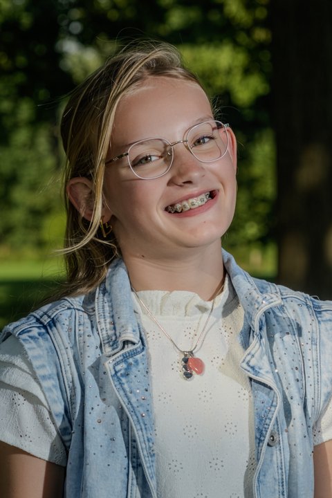 A girl smiling towards the camera in a close portrait.
