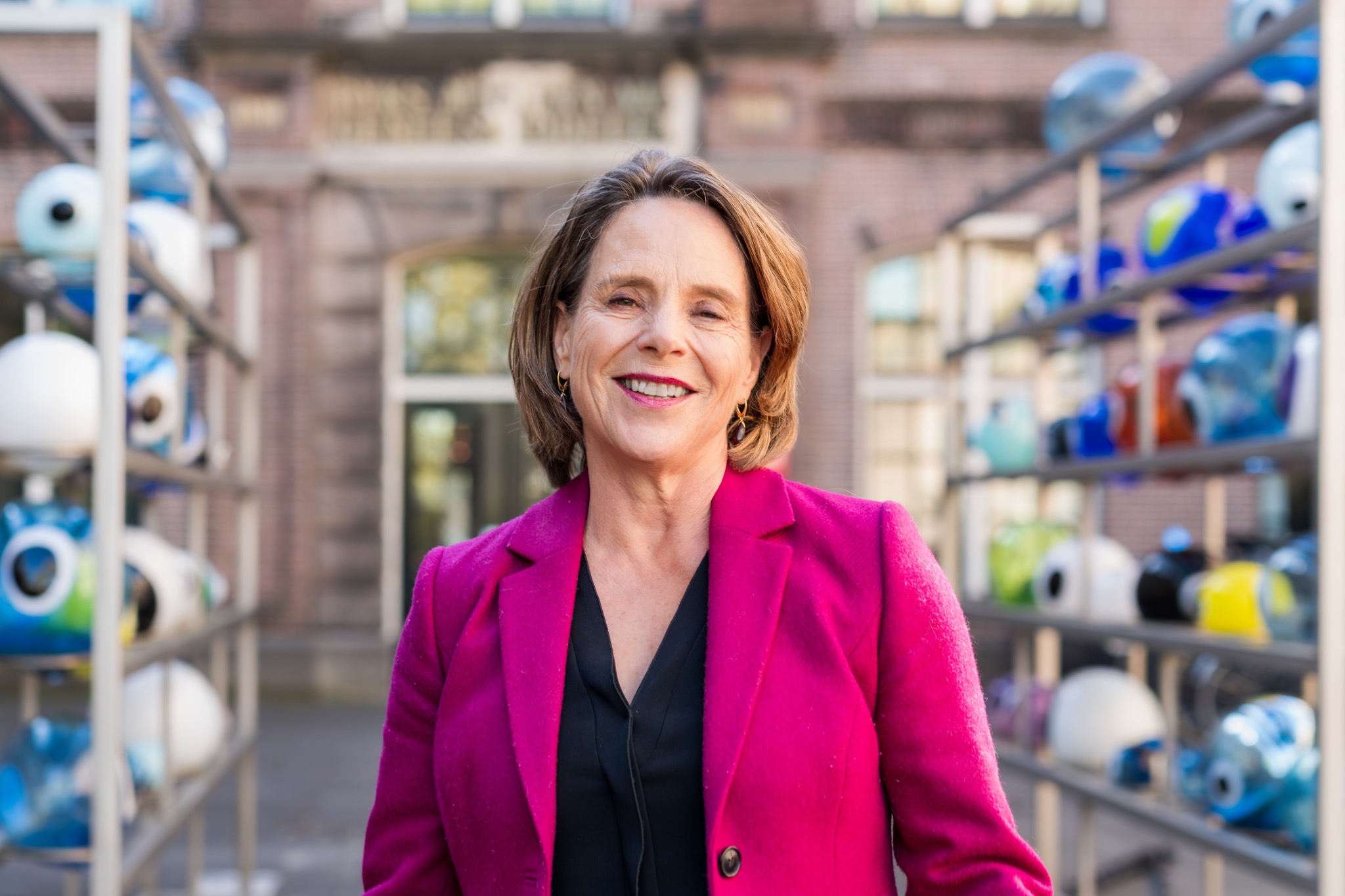 Senior leider in een opvallend jasje in een architectonische omgeving