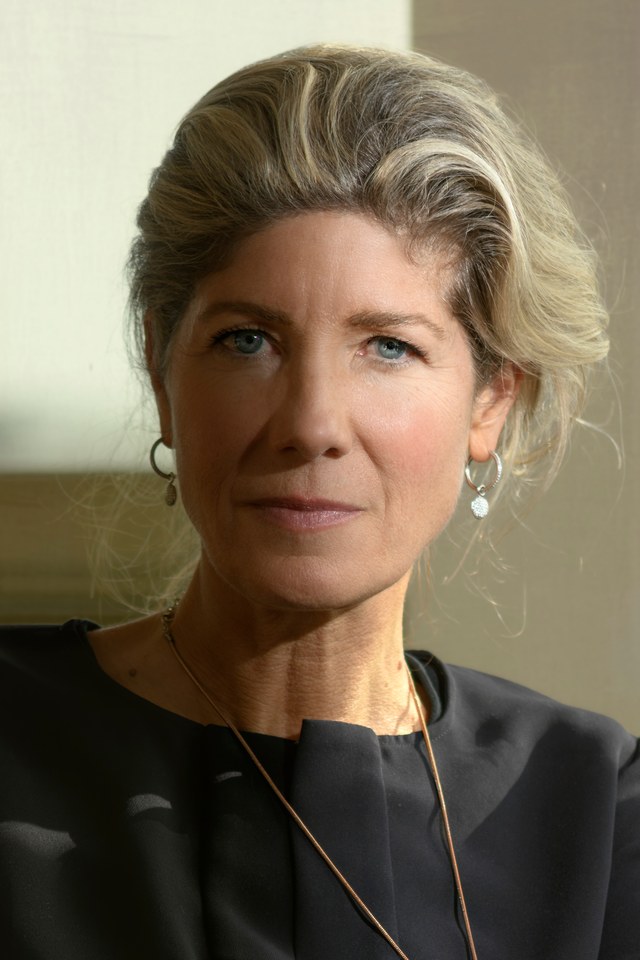 Close portrait of a woman, looking directly at the camera in window light.