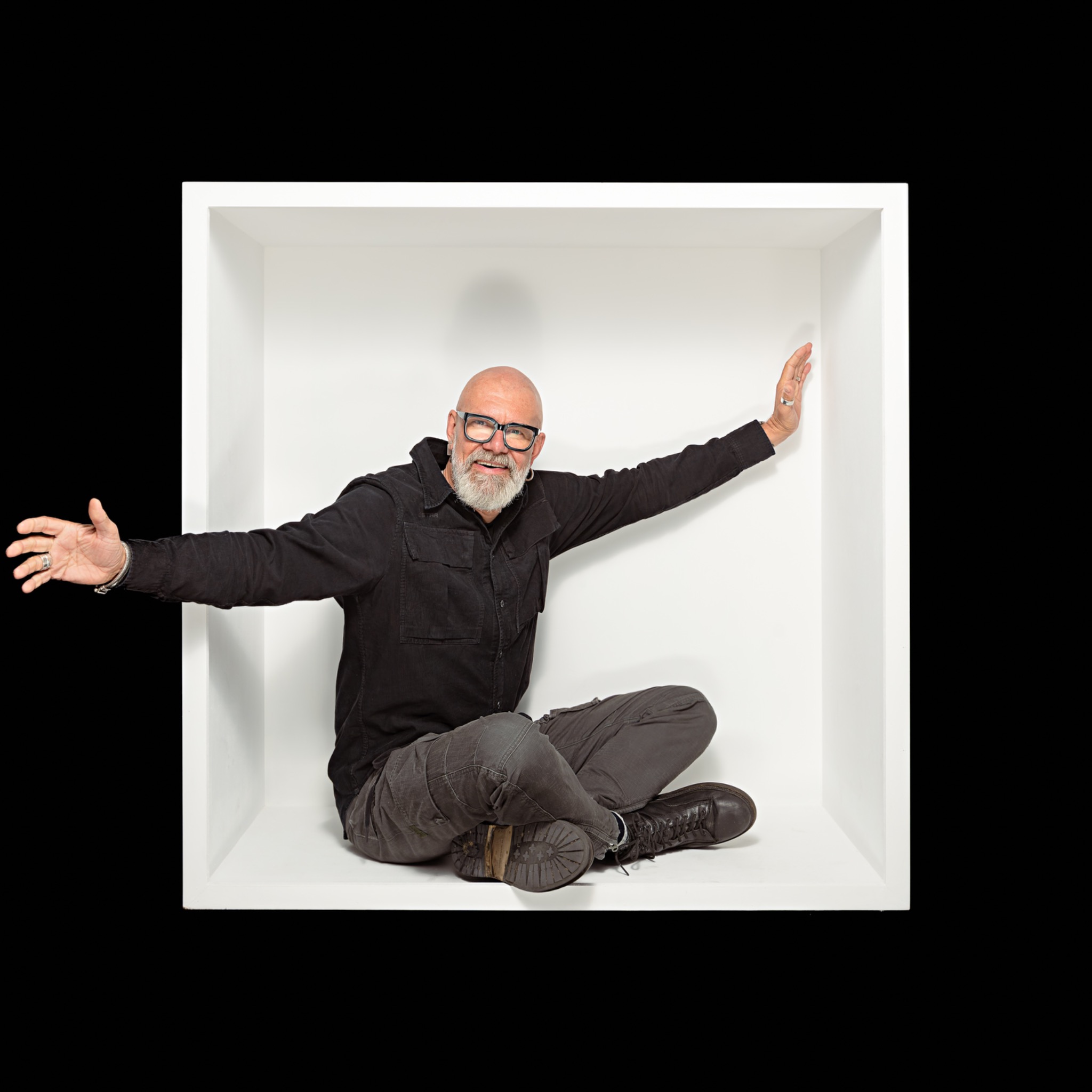 White-box-portret van een zittende man met één arm buiten het kader
