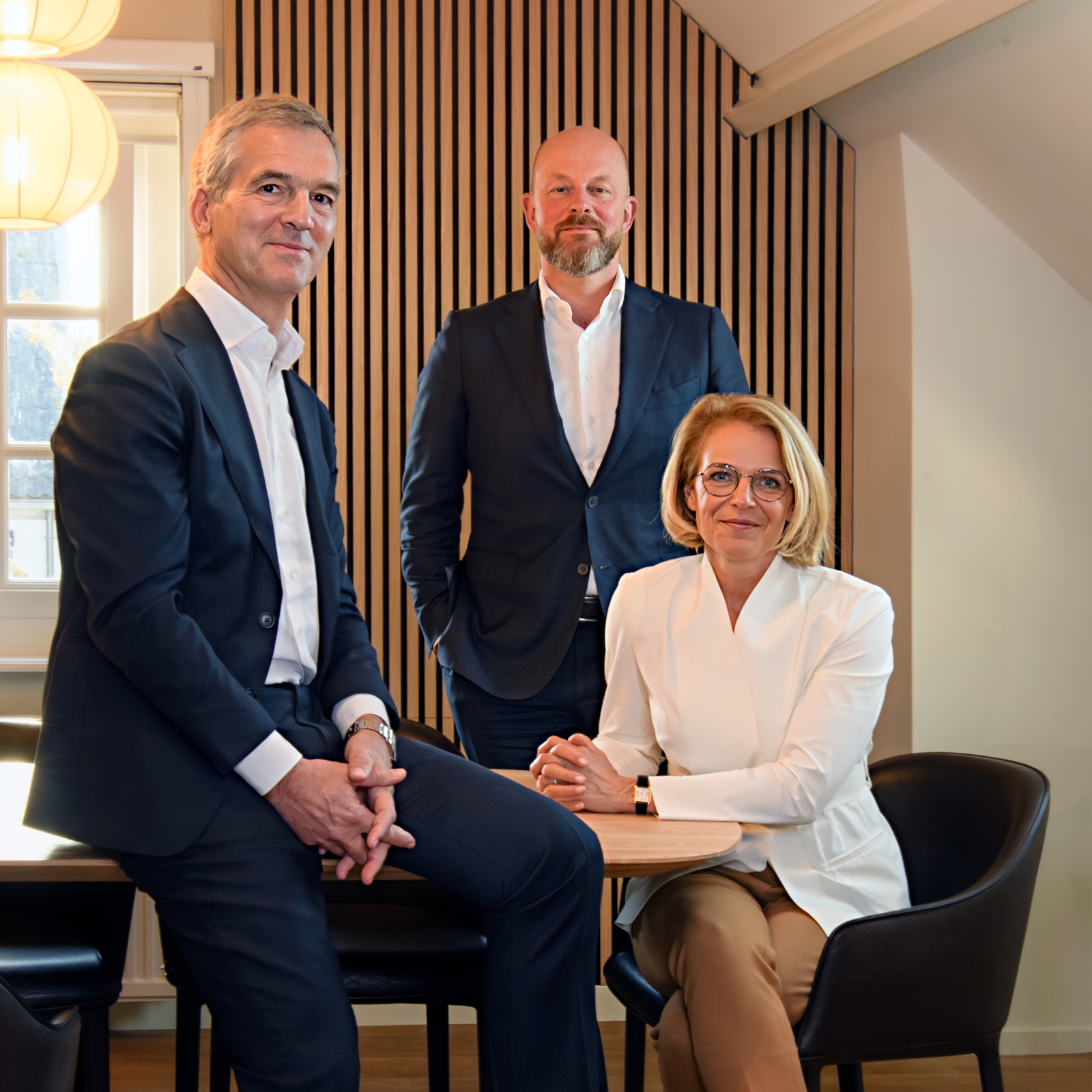 Three P5COM colleagues photographed together at their office