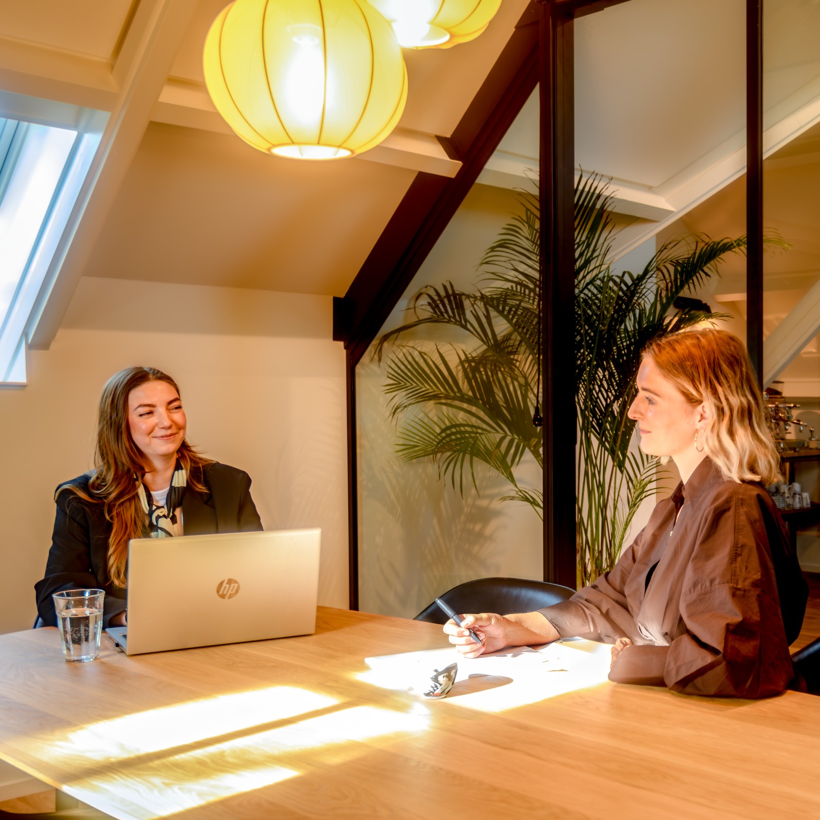 P5COM colleagues talking across a table in their office