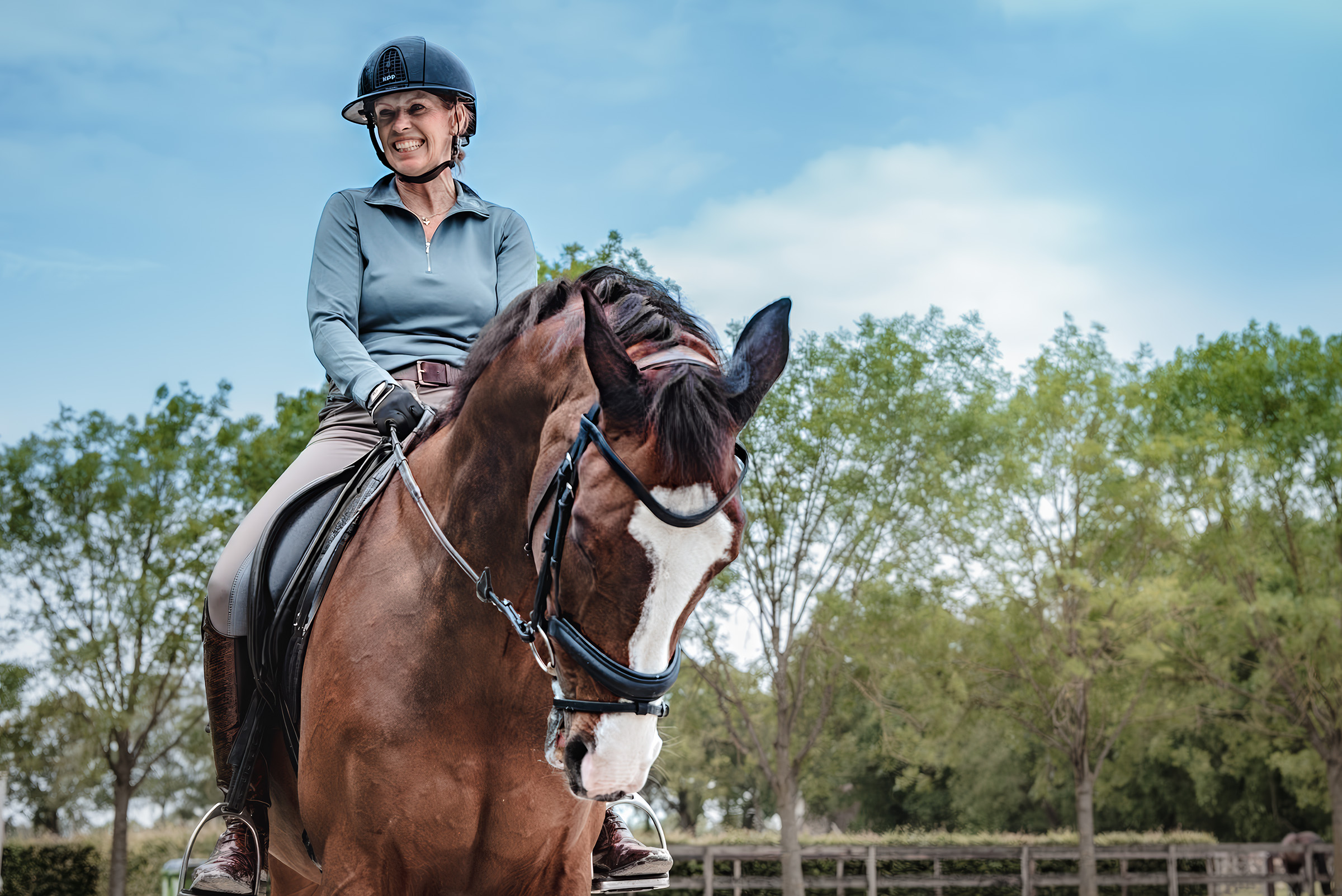 Anky van Grunsven riding a chestnut horse outdoors