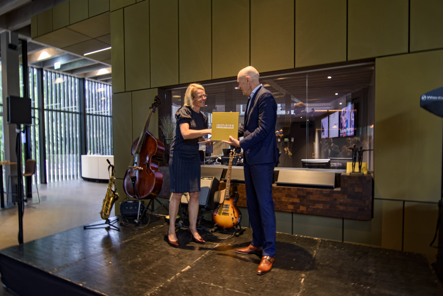 The yellow Inspiring Performance book is handed over on stage during P5COM’s anniversary.